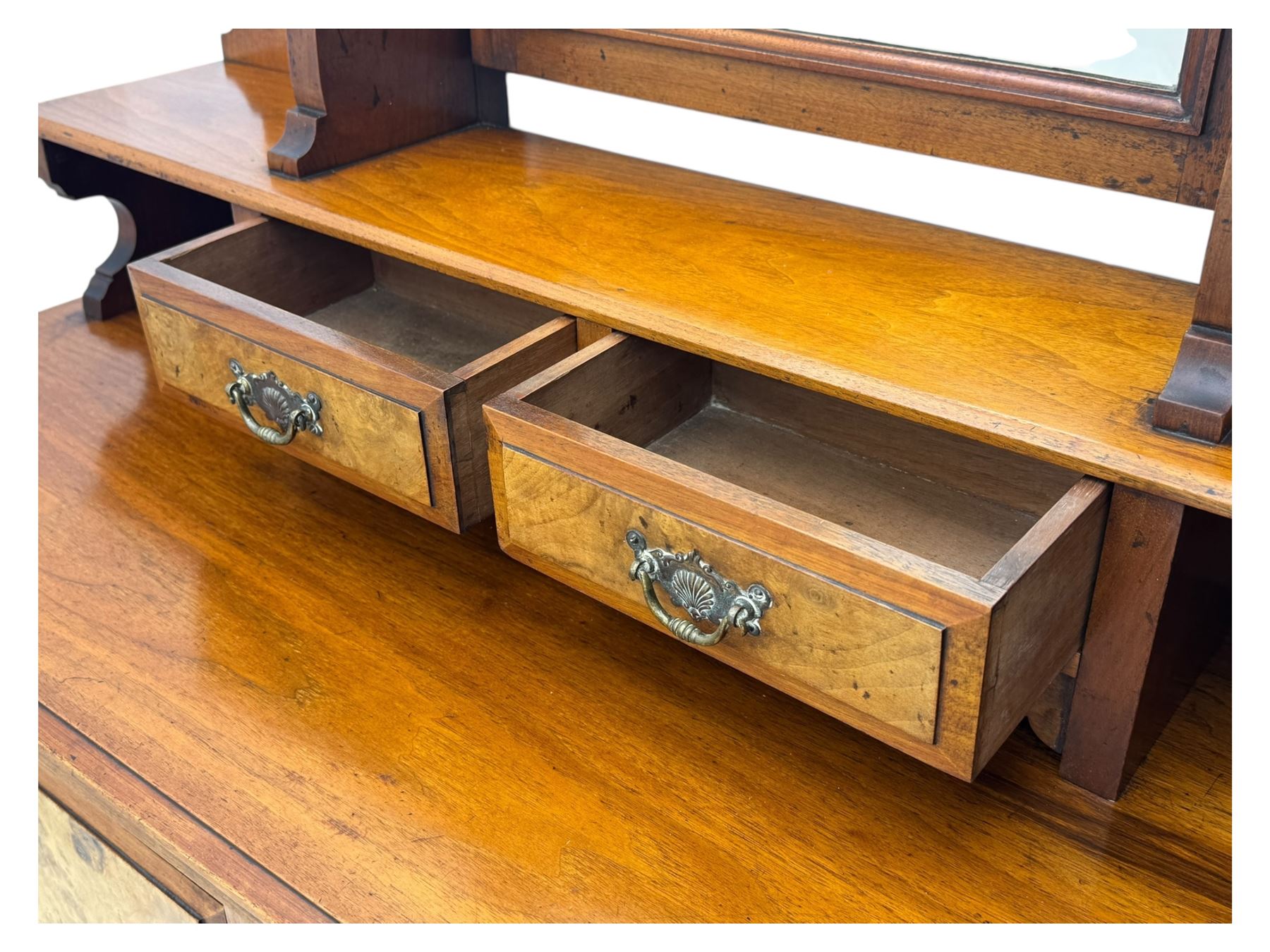 Victorian walnut bedroom suite - wardrobe, dressing chest and bedside cupboard, comprising a full-length wardrobe with broken pediment and central mirrored door, large lower drawer, a matching dressing table with bevelled swing mirror over two trinket drawers and two short drawers over two long drawers, and a single-door bedside cupboard, all with moulded edges, decorative panel work and shaped aprons