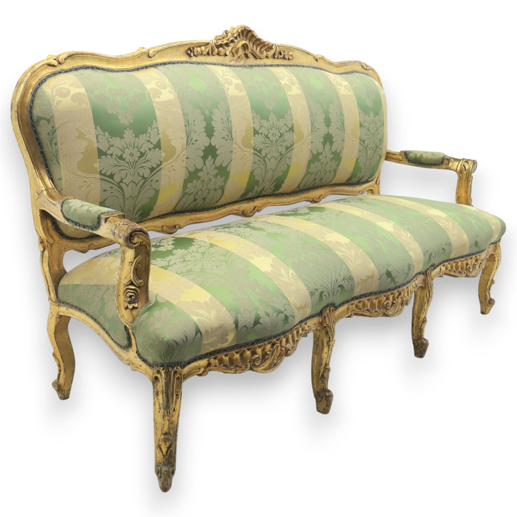 20th century French Louis XV style giltwood salon sofa, with shaped and moulded serpentine cresting rail carved with central scroll motif, padded back and seat upholstered in green and gold striped damask fabric, scroll carved open arms with padded rests, shaped apron carved with rocaille and foliate motifs, raised upon cabriole legs
