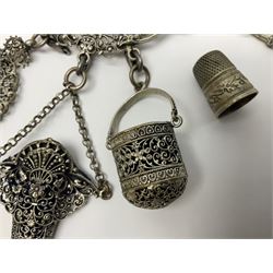 19th century continental silver plated chatelaine, the main body flanked with winged mythical beasts and central soldier slaying a dragon supporting three suspended items to include velvet lined small basket and long clasped filigree chain, together with a thimble