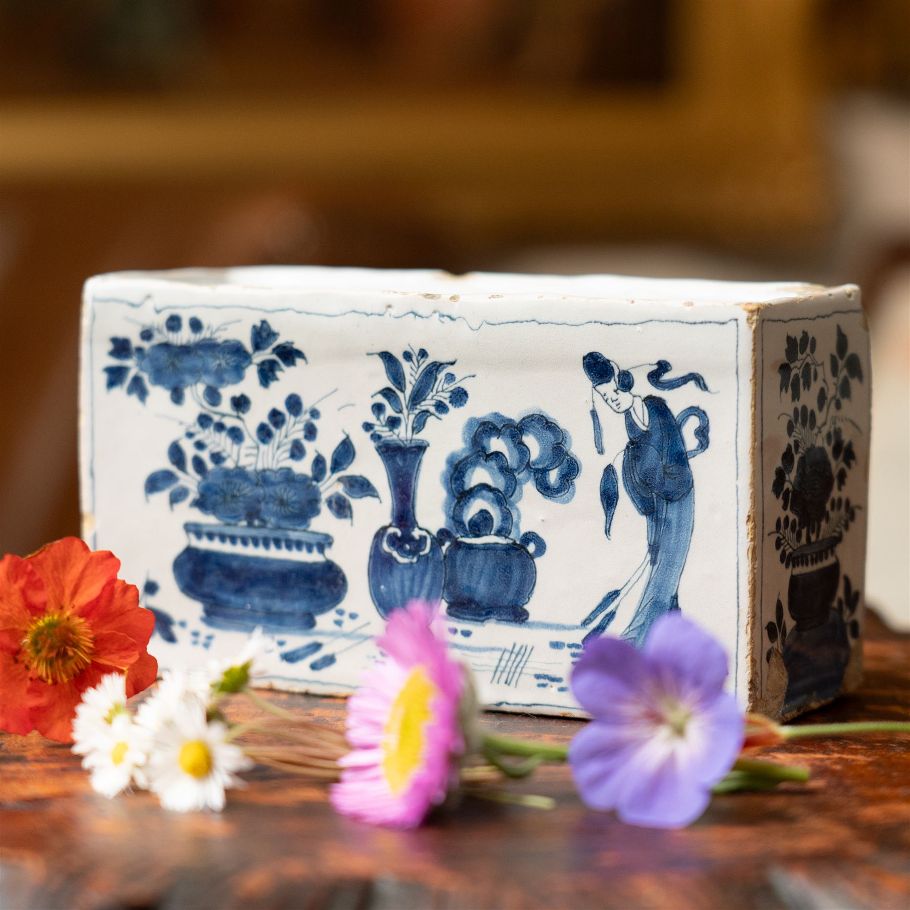 18th century English Delft flower brick, painted with a Chinese figure stood beside antiques, W16.5cm