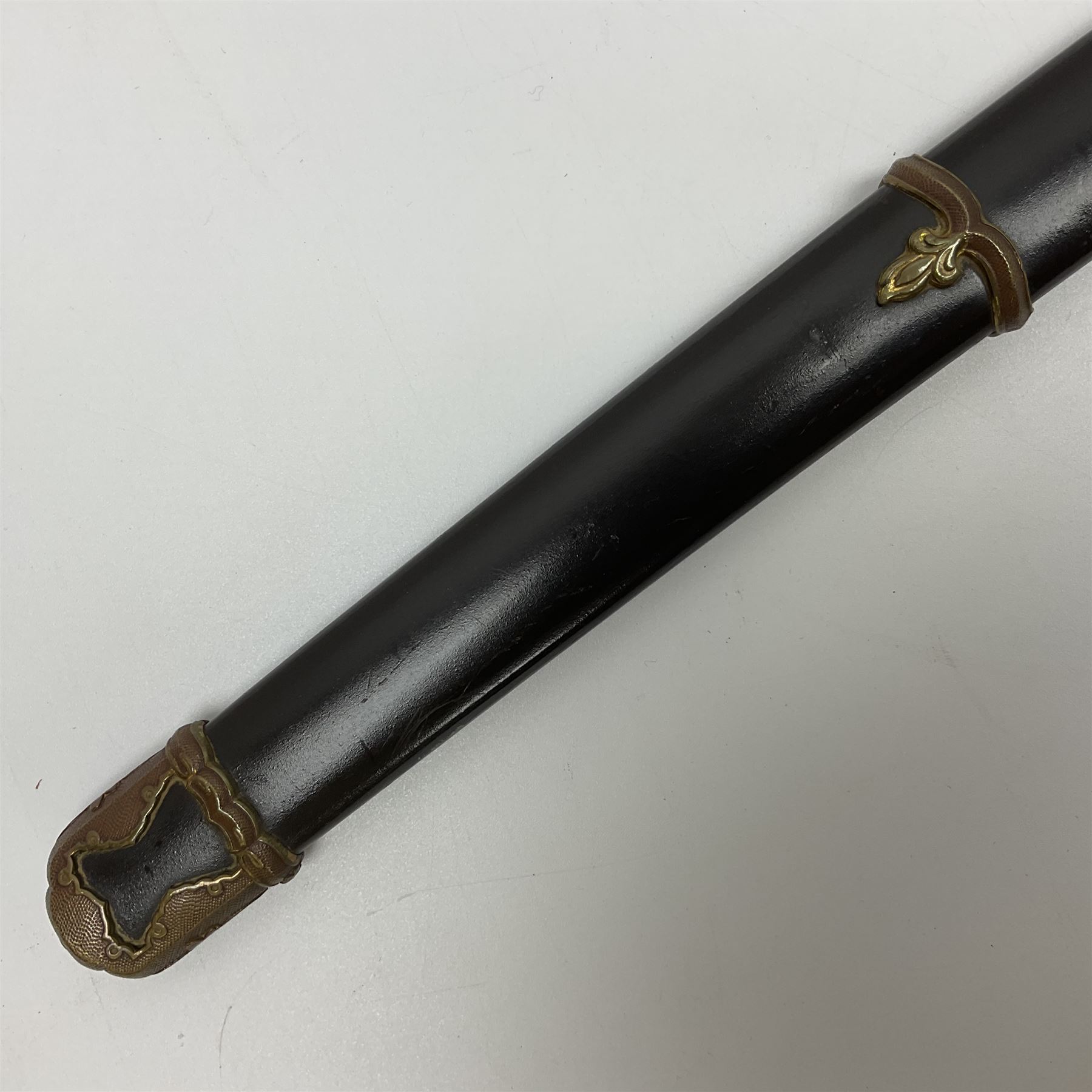 WW2 Japanese Army officer's shin gunto/katana sword with 68.5cm steel single edged blade, foliate cast brass tsuba, bound fish-skin grip with brass mounts, inscribed marks to both sides of tang; in lacquered wooden scabbard with brass mounts and locking button L97cm overall