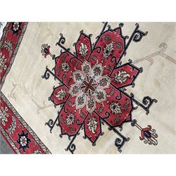 Persian Heriz rug, the ivory ground field with large floral central medallion and pale linear decoration, red ground guarded border with stylised floral and foliage motifs