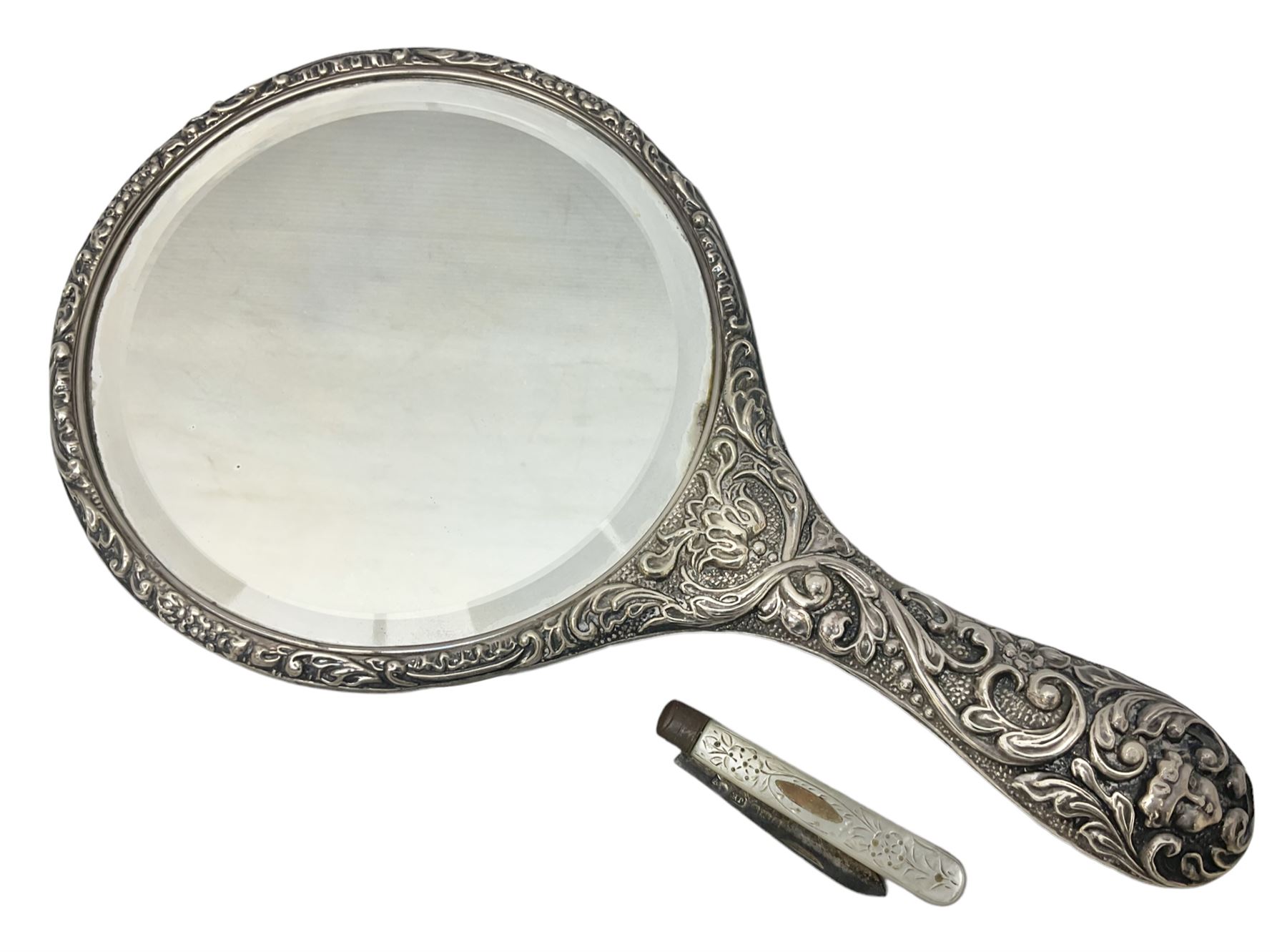 Silver mounted dressing table mirror, embossed with birds, masks, and foliate and C scrolls, hallmarked Birmingham, and fruit knife with mother of pearl handle and silver blade, (2)