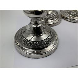 Four George III silver candlesticks, each upon knopped stem and weighted circular stepped foot, the foot and removable sconce repousse decorated with a band of flower heads, hallmarked to sconce and foot Thomas & John Settle, Sheffield 1820, H17.5cm