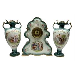 Three piece ceramic clock garniture, the clock with shaped surround decorated with transfer printed figural panel and roses against a blue ground, flanked by a pair of similarly decorated twin handled vases