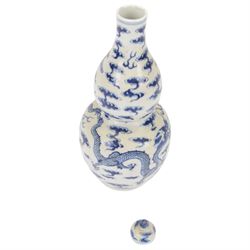Chinese Kangxi style double-gourd form vase, the blue and white vase surmounted by a domed cover, decorated with dragons chasing a flaming pearl, four-character mark to beneath, H31cm