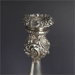 Pair of late Victorian silver candlesticks, each embossed wth floral, foliate and scrolling decoration, with removable sconces and upon a weighted embossed base, hallmarked Jenkins & Timm, Sheffiled 1891, H20cm