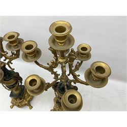 Pair of 20th century continental seven branch candelabras, gilt metal and variegated green marble, with cherub decoration raised on a plinth with paw feet, H61cm