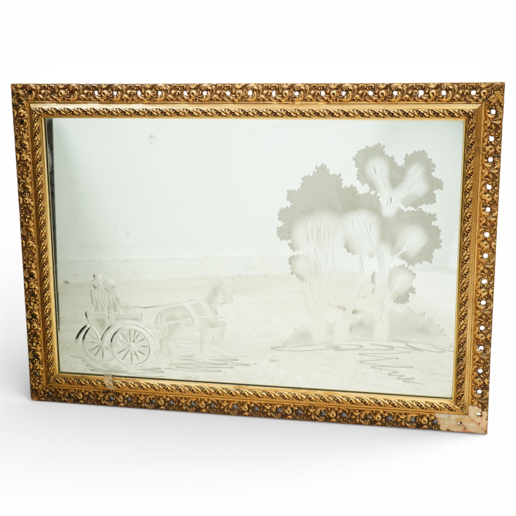 20th century giltwood and gesso wall mirror, rectangular form with pierced foliate and scroll moulded frame, rope twist inner moulding, enclosing an engraved mirror plate decorated with a horse drawn carriage and stylised trees