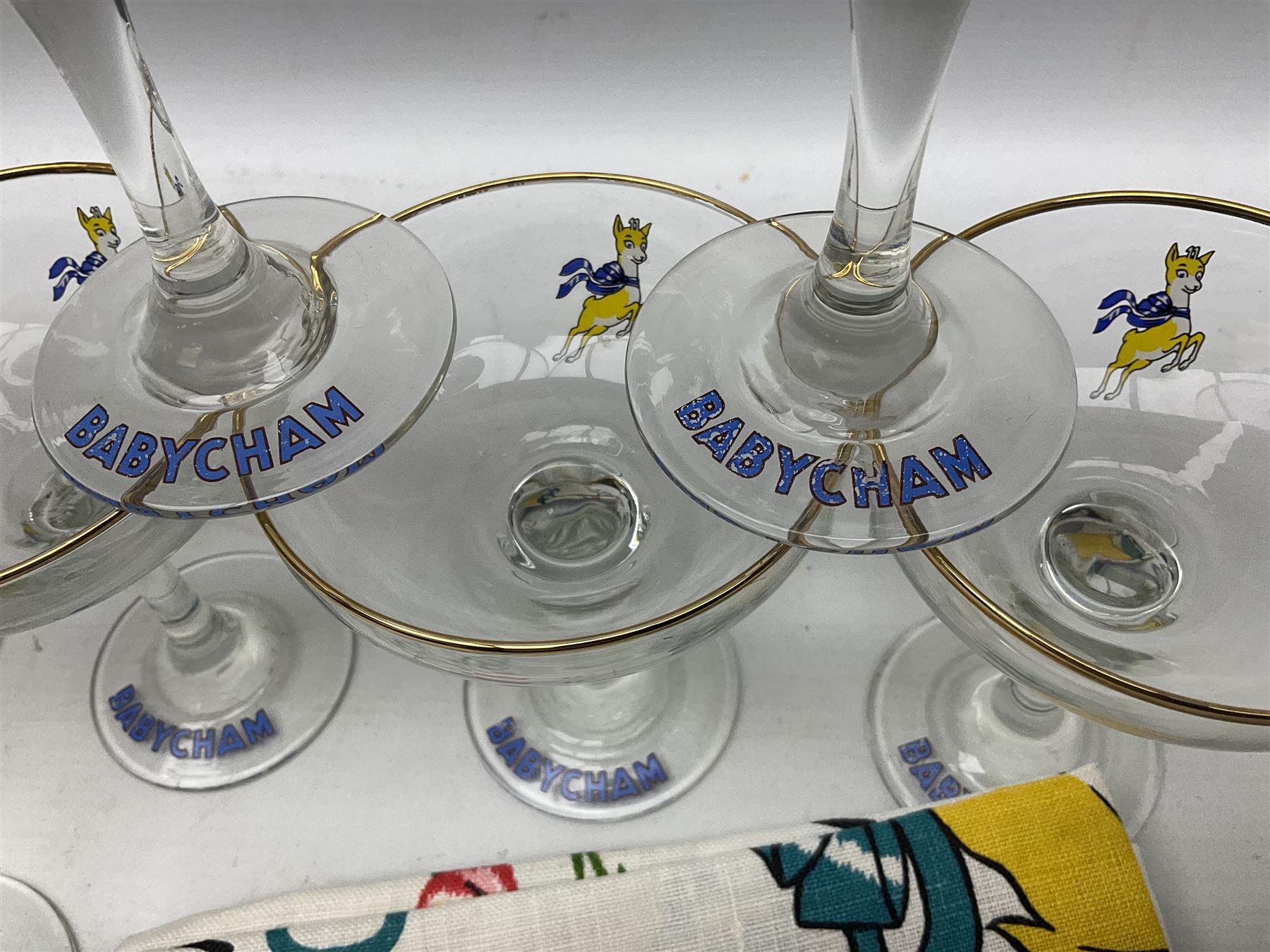 Breweriana; Eight Babycham glasses together with a Babycham plastic fawn mascot and linen I'd Love a Babycham tea towel