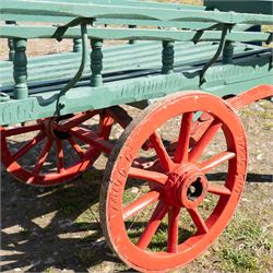 Costermonger’s Cart

A painted costermonger’s cart with green slatted timber body, red painted wooden spoked wheels and red leaf spring suspension. The cart is fitted with raised side rails, turned supports and short projecting handles. Painted lettering is visible along the side rails, together with the number “661” to the frame and wheel rim.
Finished in traditional colours, the cart offers excellent decorative appeal and would be suitable for display, garden or country house settings.

Dimensions:
Overall length: 240 cm
Body length: 215 cm
Width: 94 cm
Height: 86 cm
Wheel diameter: 64 cm

Features:
Timber construction
Open slatted carrying platform
Shaped side rails
Leaf spring suspension
Wooden spoked wheels
Iron tyres
Iron fittings throughout
Carved ownership and maker inscriptions
Traditional painted finish

