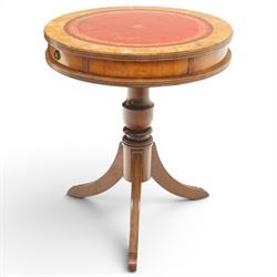 Regency style mahogany drum table, circular red leather inset top with gilt and blind tooling, bird's-eye maple crossbanded border, fitted with two opposing pull-out slides, on turned pedestal and three outswept support