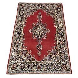 Persian Kashan red ground rug, plain field decorated with floral medallion and spandrels, repeating border with scrolling flower head design 