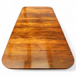 Regency rosewood sofa table, rectangular top with variegated rosewood veneers, hinged D-shaped leaves, over a set of dummy drawers to the back and full-size drawers to the front, with turned knob handles and gilt beaded moulding on frieze above elegant turned, tapering, and fluted, pedestal with a well-carved collar, supported on a large, tripartite concave platform base terminating in richly carved lion paw feet with gilded acanthus leaf carving, on concealed brass castors, circa 1815, length extended 161cm 
