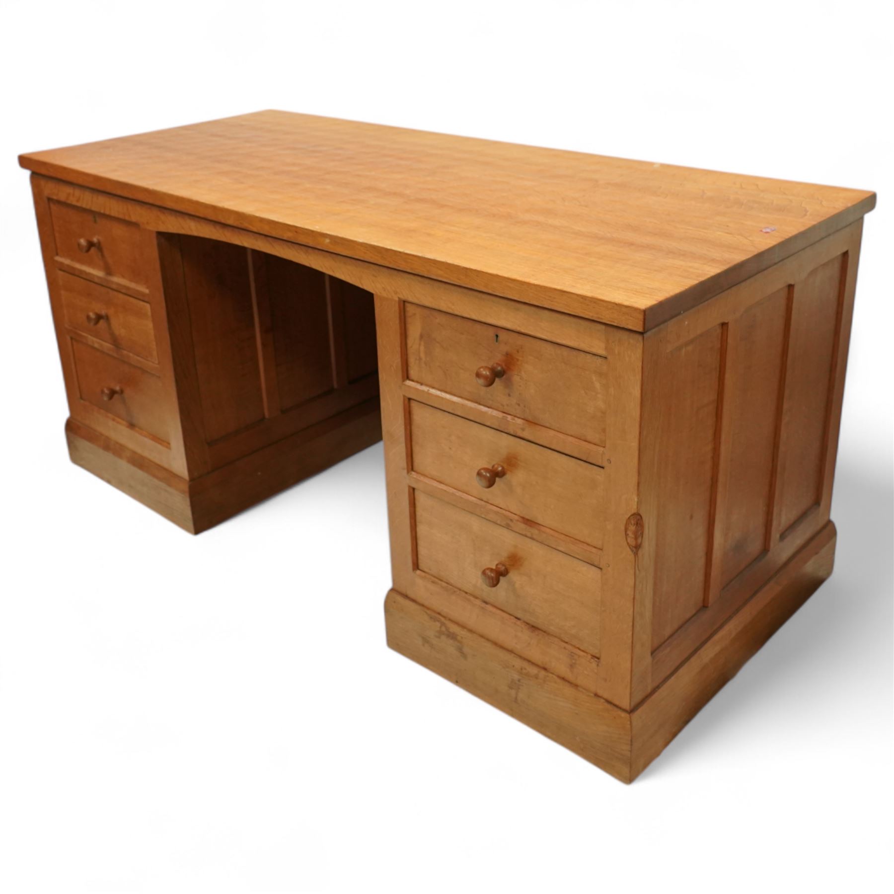 Mouseman - oak pedestal kneehole desk, adzed rectangular top over twin pedestals each fitted with three drawers, arched kneehole with panelled interior, on plinth base, signature carved mouse to side, by the workshop of Robert Thompson, Kilburn