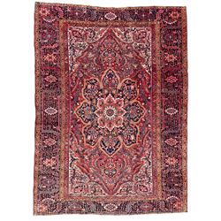 Antique Persian coral ground carpet, the large central floral pole medallion with extending foliate designs, the thick guarded indigo border with repeating flower heads and circles