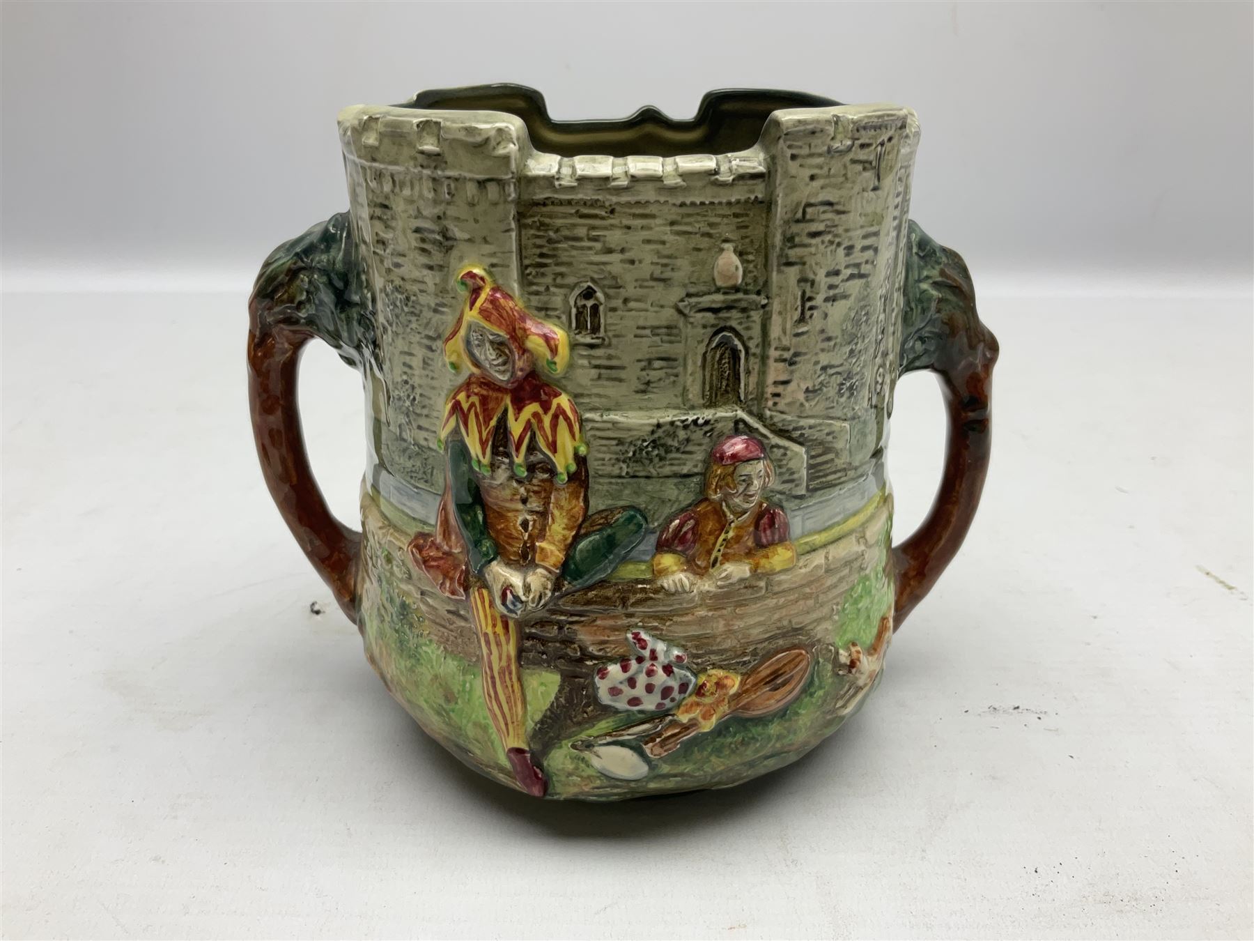 Royal Doulton Wandering Minstrel loving cup modelled by Charles Noke, decorated with figures with a castle in the background, mark to base 'A Wandering Minstrel A Merry Man Moping Mum' limited edition 7/600, H14cm