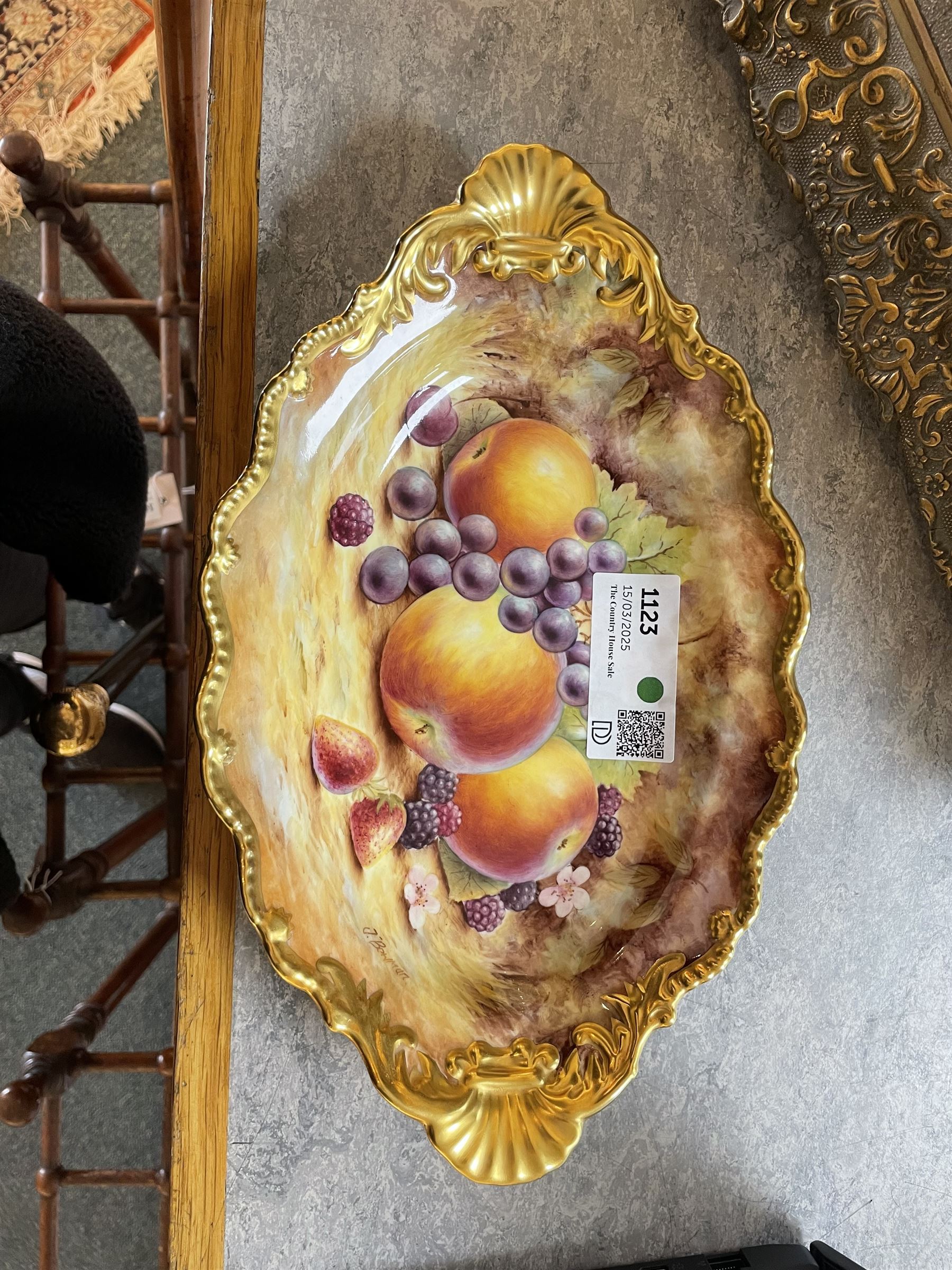 Late 20th century Royal Worcester dish, of oval form with gilt shaped rim and twin shell handles, hand painted by Jason Bowman with still life of fruit upon mossy ground, signed J Bowman, wit marks beneath, with makers fitted card box



