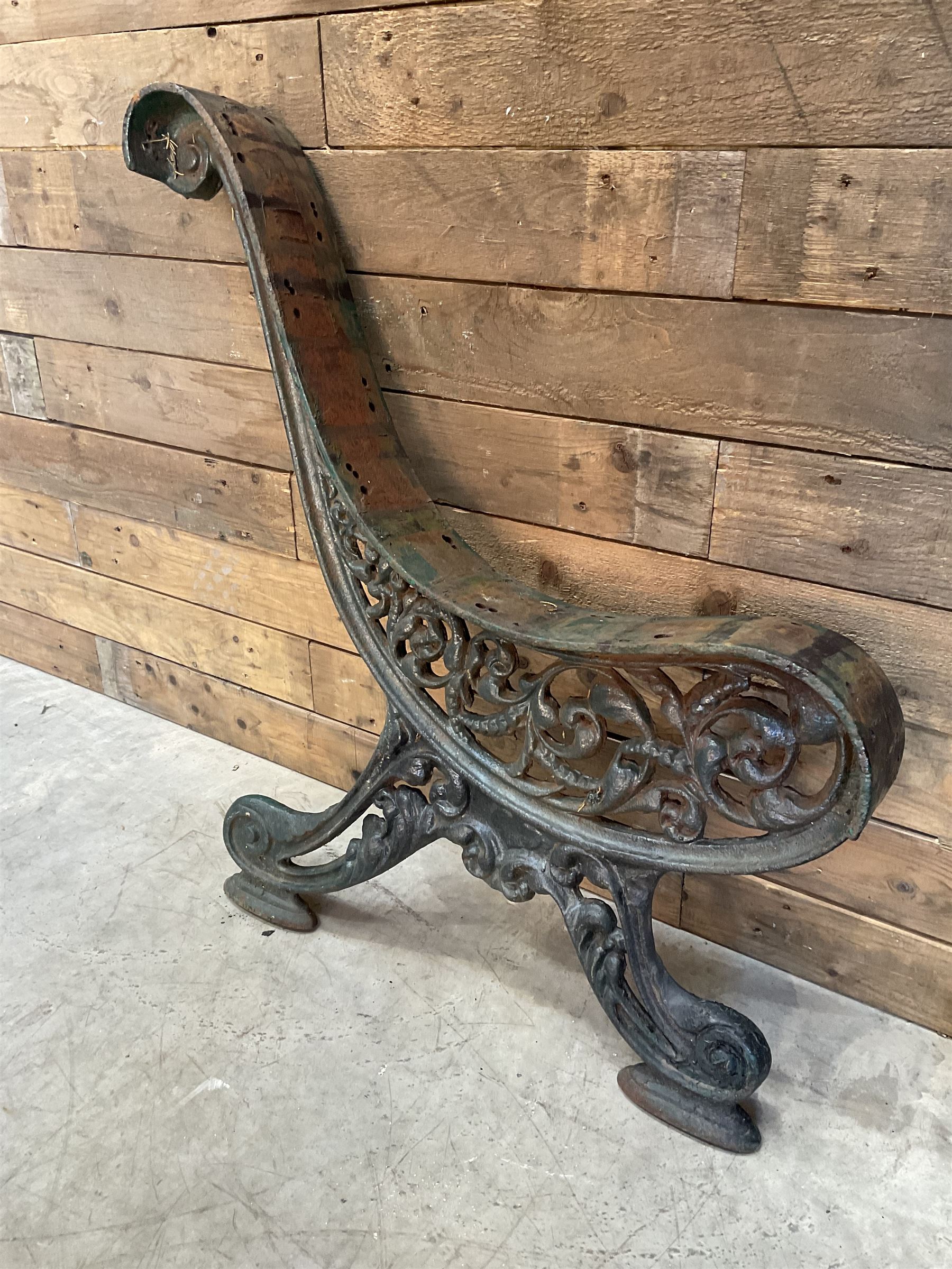 Early 20th century heavy cast iron three piece bench ends, decorated with scrolls and floral swags