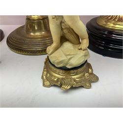 Victorian cast brass oil lamp, with fluted pink glass shade, together with two smaller brass oil lamps with pink shades and reservoirs and a pair of oil lamps, the bases modelled as putti, with pink glass reservoir  and frosted shades, tallest H70cm