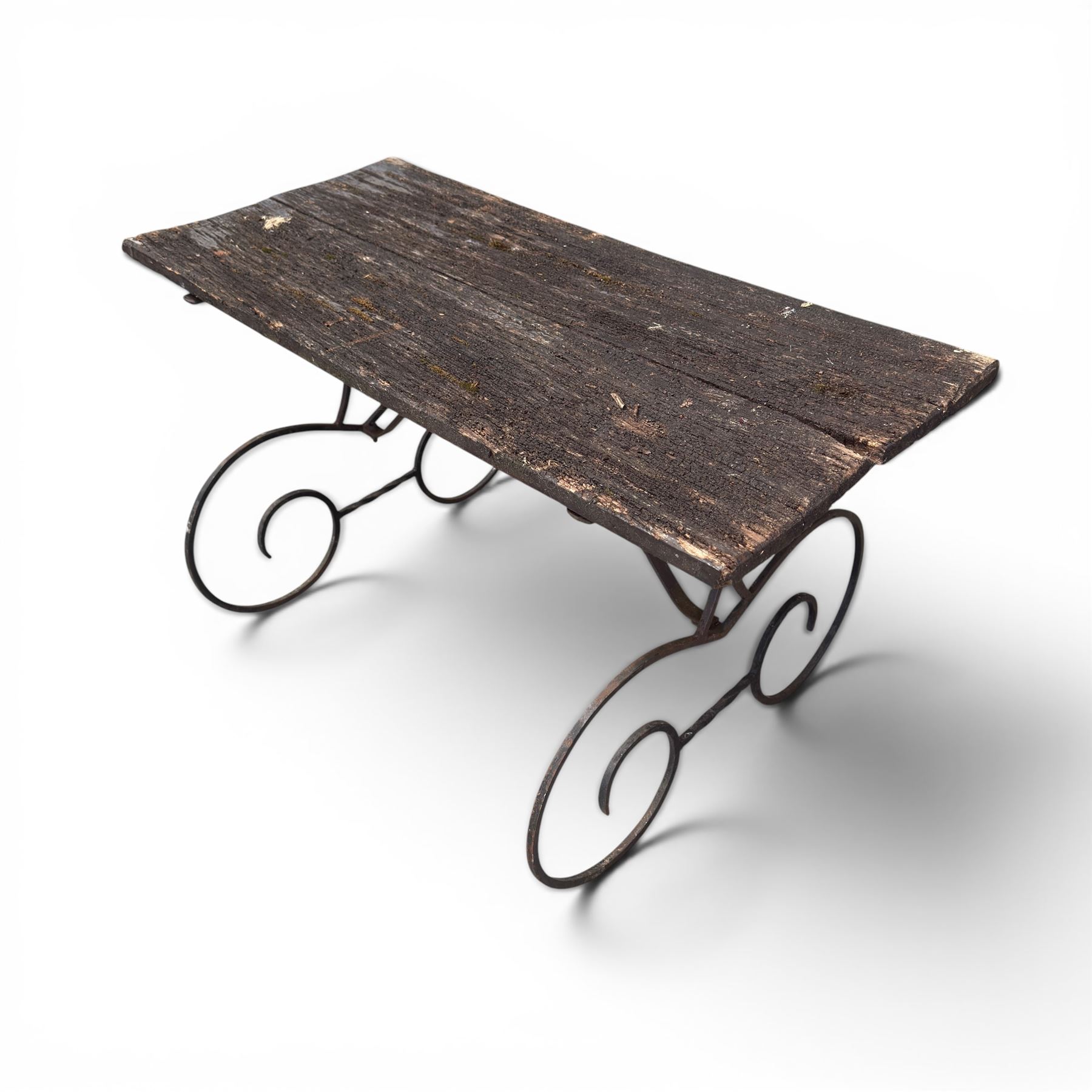 Cast iron garden table, with rectangular weathered slatted wooden top, raised on iron strapwork supports of scrolling form, in black painted antique finish 