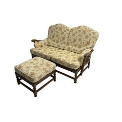 Ercol elm two seat sofa (W155cm, D100cm, H100cm), and matching footstool (60cm x 60cm, H44cm), loose cushions upholstered in floral pattern fabric
