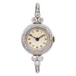 Platinum Art Deco milgrain set diamond manual wind lever wristwatch, cream enamel dial with Arabic numerals, diamond set bezel, the case spaced by two groups of three diamonds of approx 0.20 carat each, to a platinum expanding link bracelet, the first two links on each side set with diamonds, back case stamped 8942 and initialled JF with Fleur de Lys mark sitting between the letters