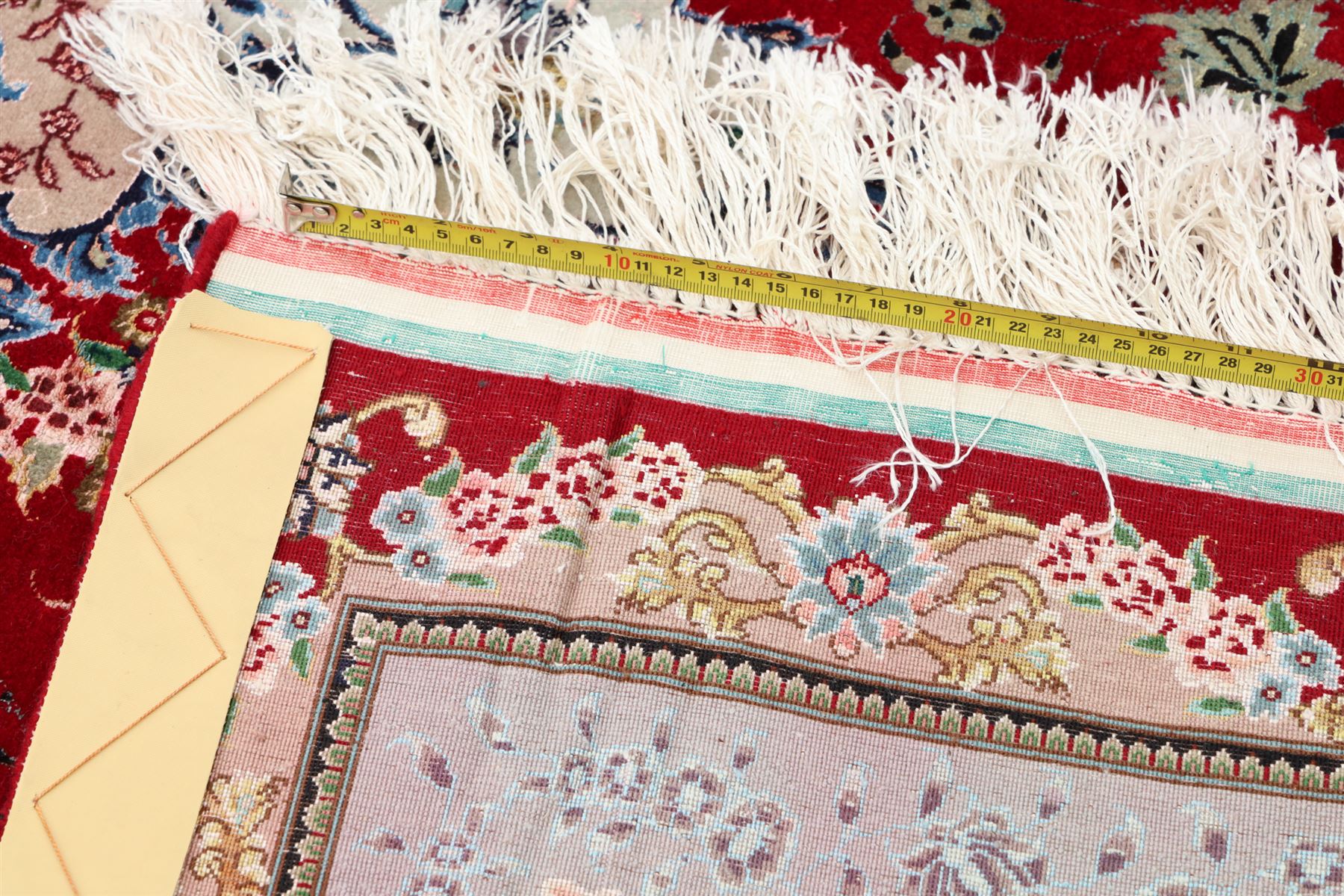 Fine Persian silk inlaid crimson ground Tabriz rug, the shaped field decorated with a central foliate pole medallion filled and surrounded by finely knotted floral motifs and trailing foliage, the cyan guard stripe with bold festoons and palmette motifs