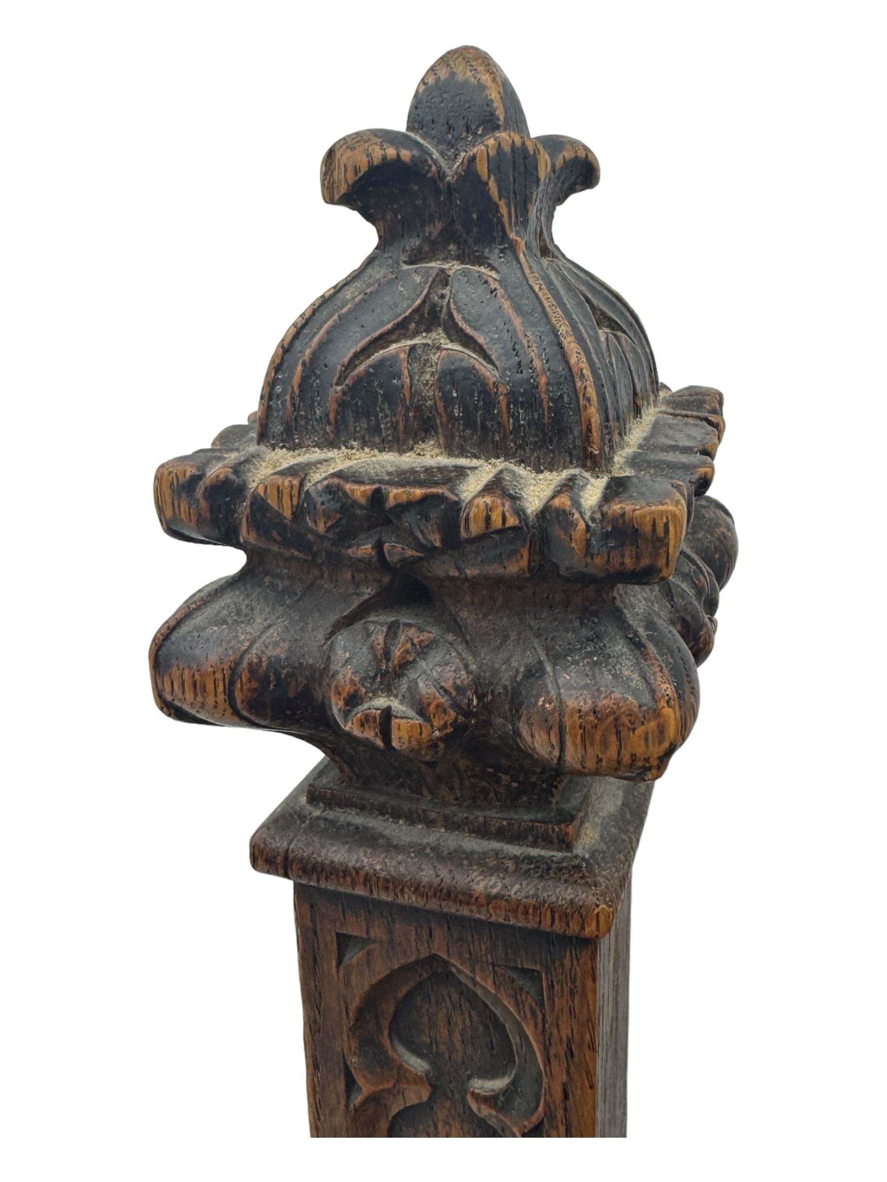 Late Victorian Gothic-revival armchair, arched crest rail carved with tracery and trefoil detail, padded circular back and seat, brass studded burgundy leather upholstery, shaped armrests with scrolled terminals, on square tapering supports