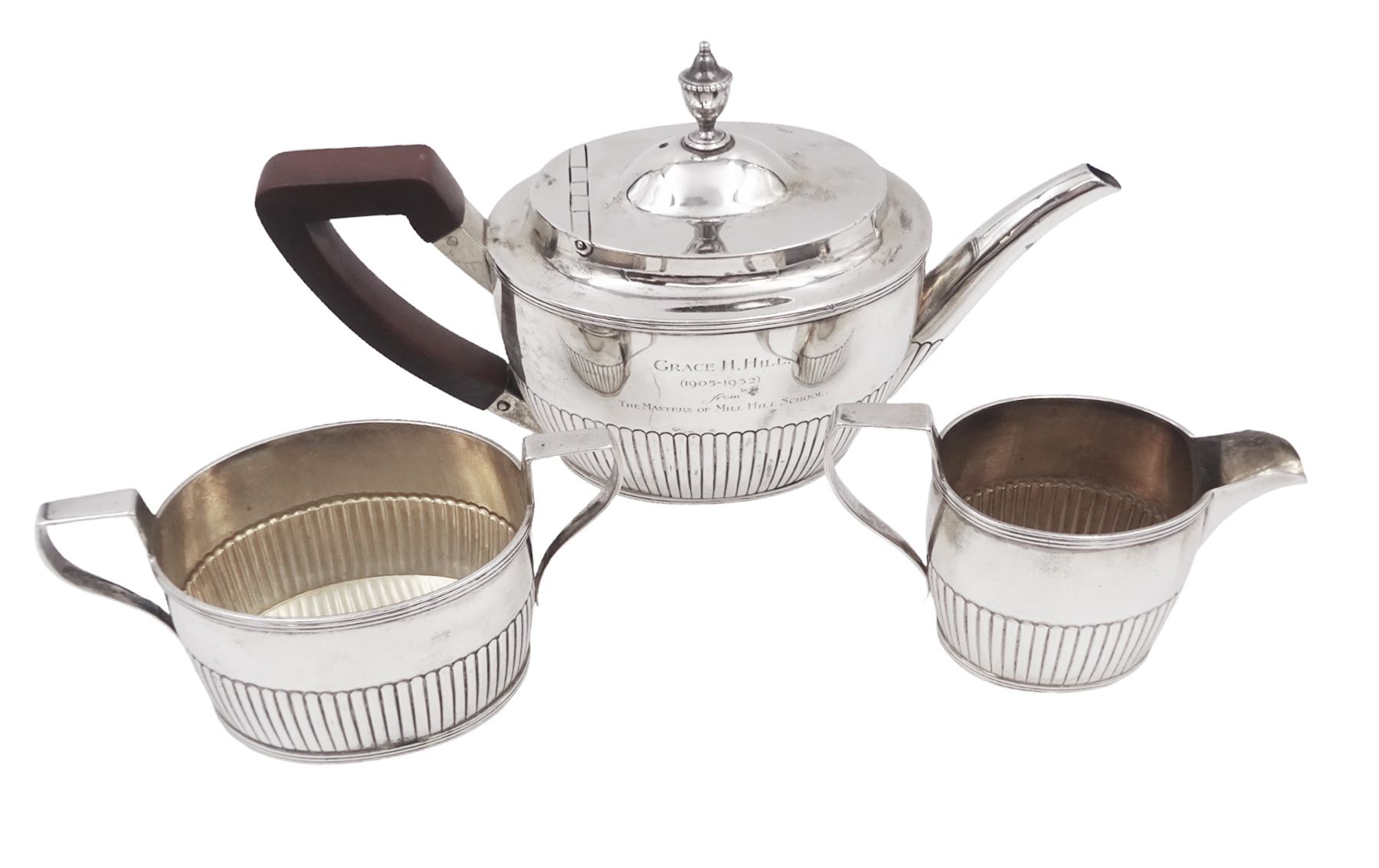 1930s American silver three piece batchelors tea service, comprising teapot, twin handled open sucrier and milk jug, each of part fluted oval form, the teapot with personal engraving to body, wood effect handle and silver urn shaped finial, stamped sterling with maker's mark for Gorham, teapot H13cm