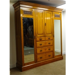  Edwardian satin walnut triple wardrobe, moulded cornice, two cupboards above two short and three long graduating drawers flanked by two bevel edge mirrored doors with urn and floral carvings, plinth base, W195cm, H213cm, D55cm  
