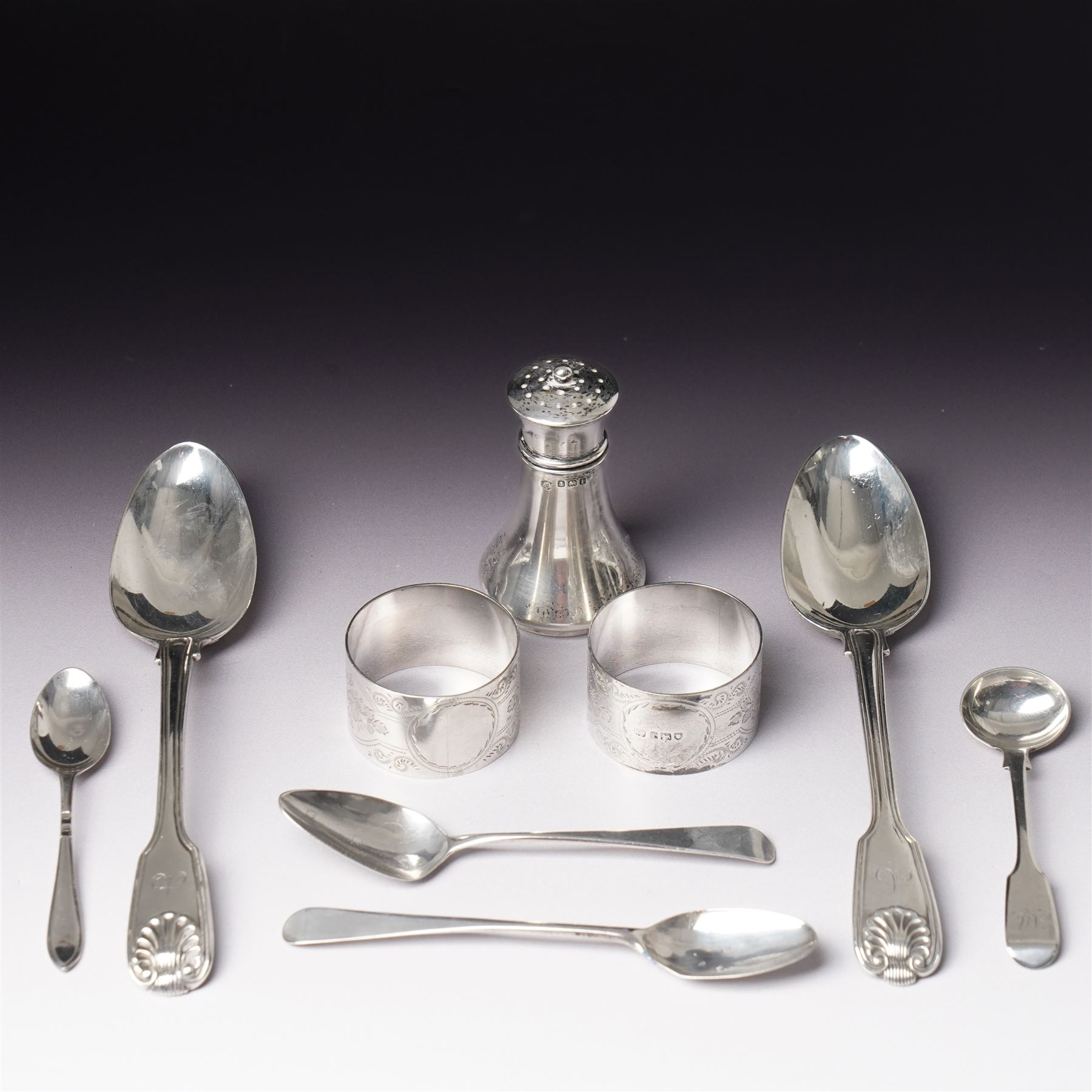 Pair of engraved silver napkin rings London 1912, two 19th century fiddle pattern dessert spoons, four condiment and teaspoons and a silver pepperette
