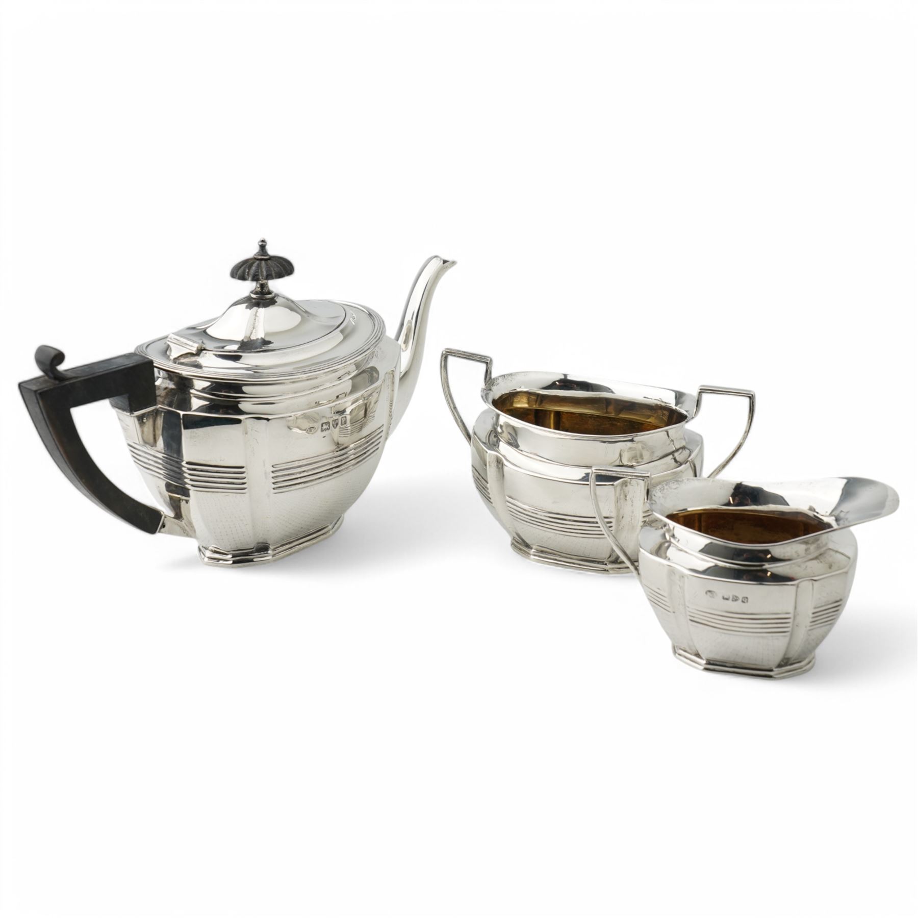 Late Victorian silver three piece tea set of panel sided oval design, the teapot with ebonised handle and lift, Chester 1898/99 Maker Florence Warden and William Aitken