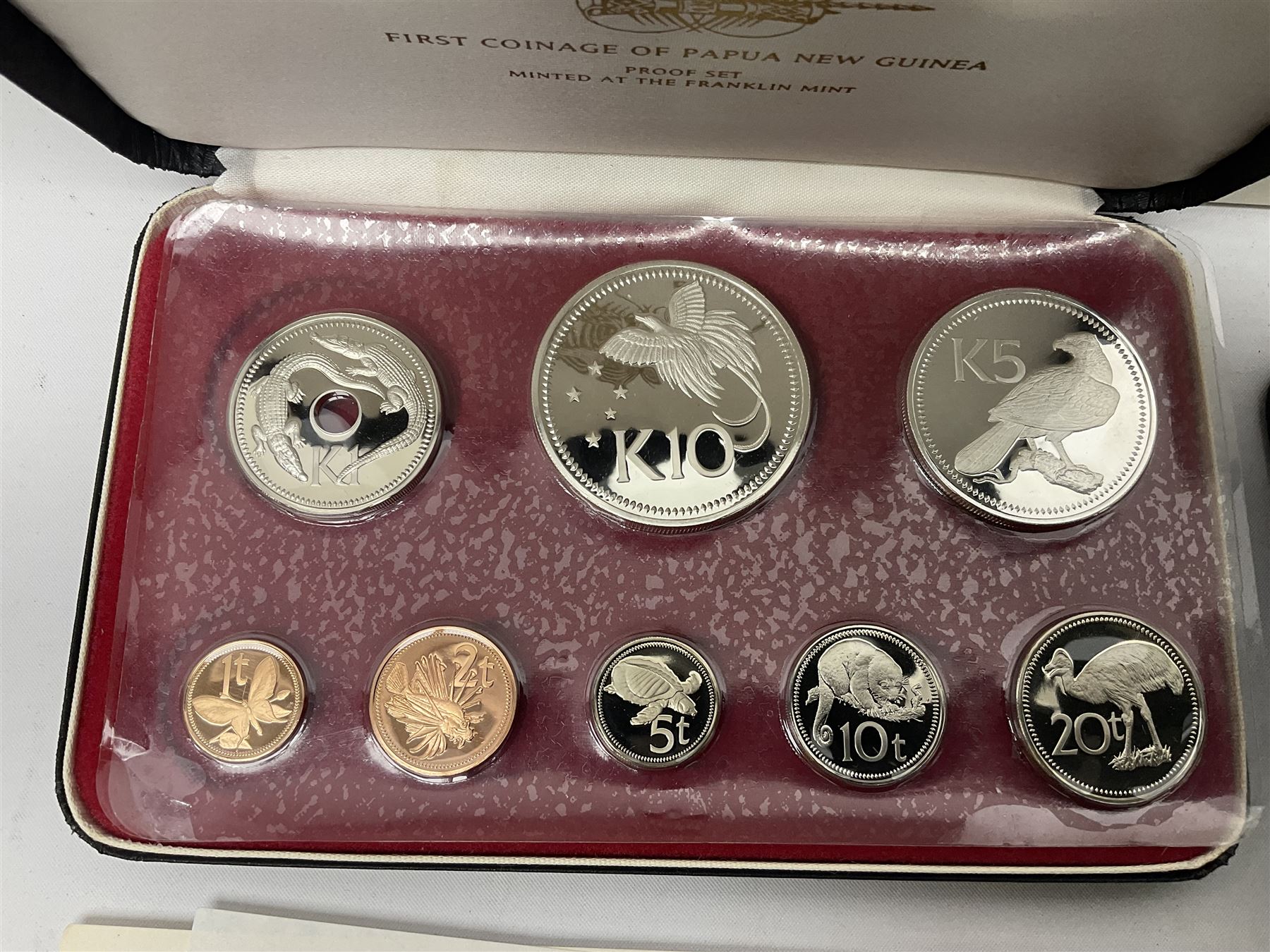 Four Papua New Guinea proof eight coin sets, from ten kina to one toea, comprising First Coinage of Papua New Guinea 1975 proof set, 1976, 1977, and 1979 proof sets, the 1977 and 1979 sets containing 925 silver ten kina and 500 silver five kina coins, all minted at the Franklin Mint, cased with certificates (4)