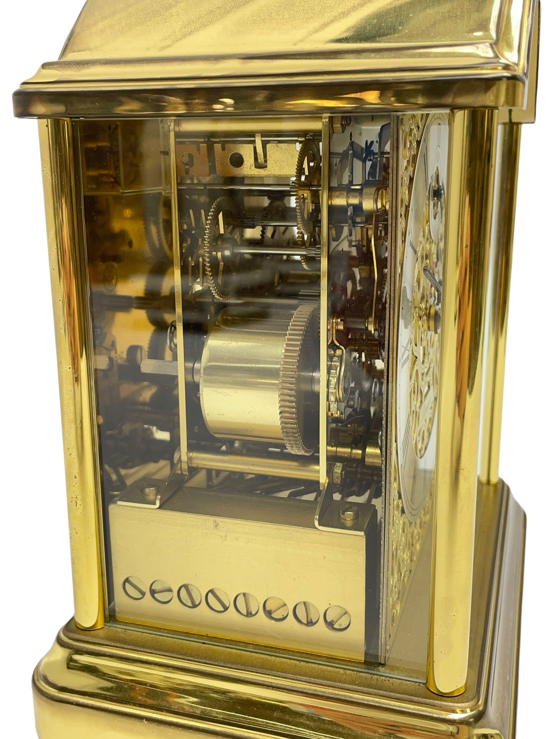 A 20th century brass cased Kieninger (German) chiming mantle clock with a break arch top and three glazed panels, polished sheet brass dial with applied  brass fretwork and a silvered chapter ring, Roman numerals, minute track, steel serpentine hands and seconds dial, three-train spring driven 8-day movement with Westminster, St Michael and Whittington chimes on 8 gong rods, 9 jewel lever platform escapement.  With key. 