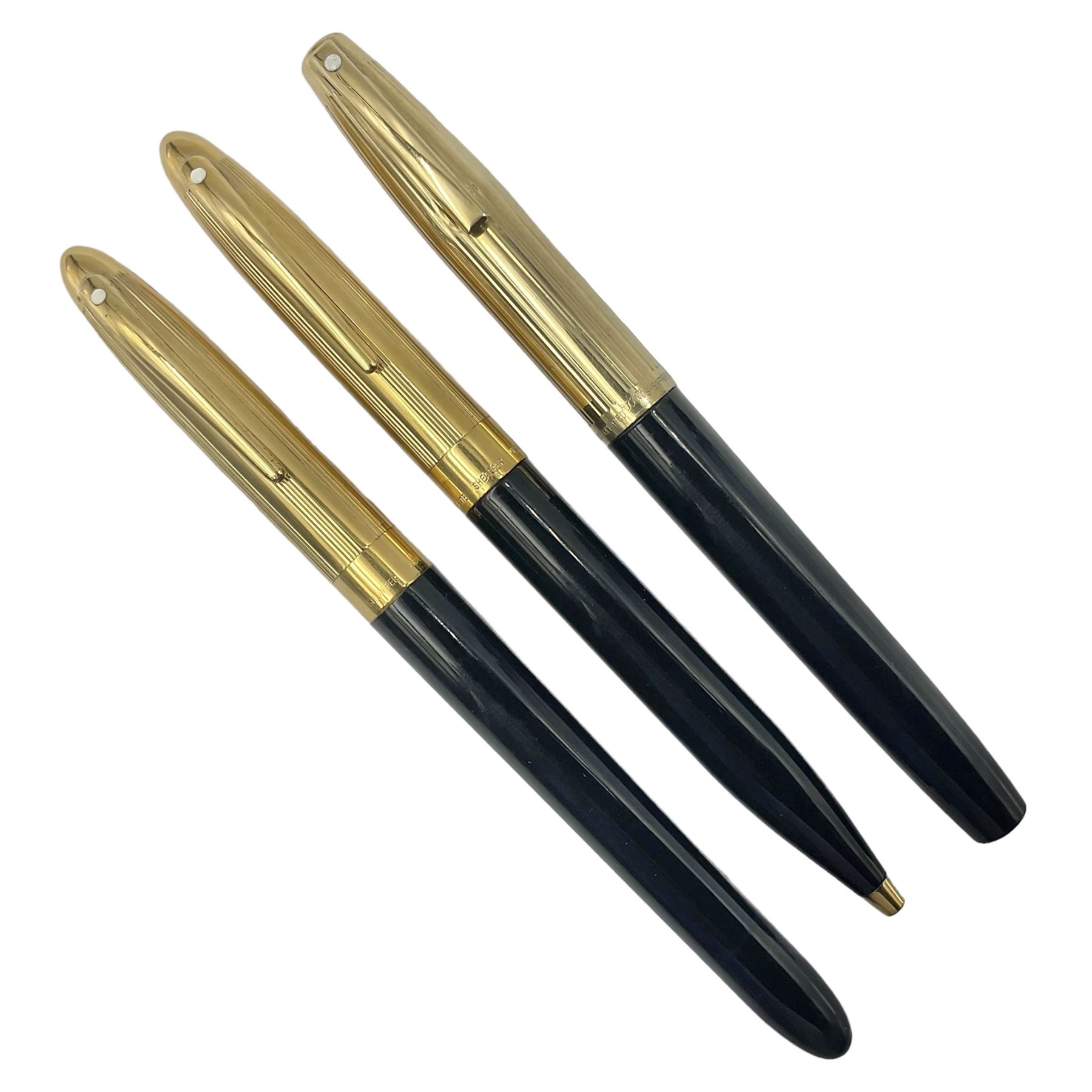 Sheaffer Crest fountain pen, the black barrel with gold plated cap and 18K nib, together with a matching ballpoint pen and further fountain pen, longest L14cm (3)