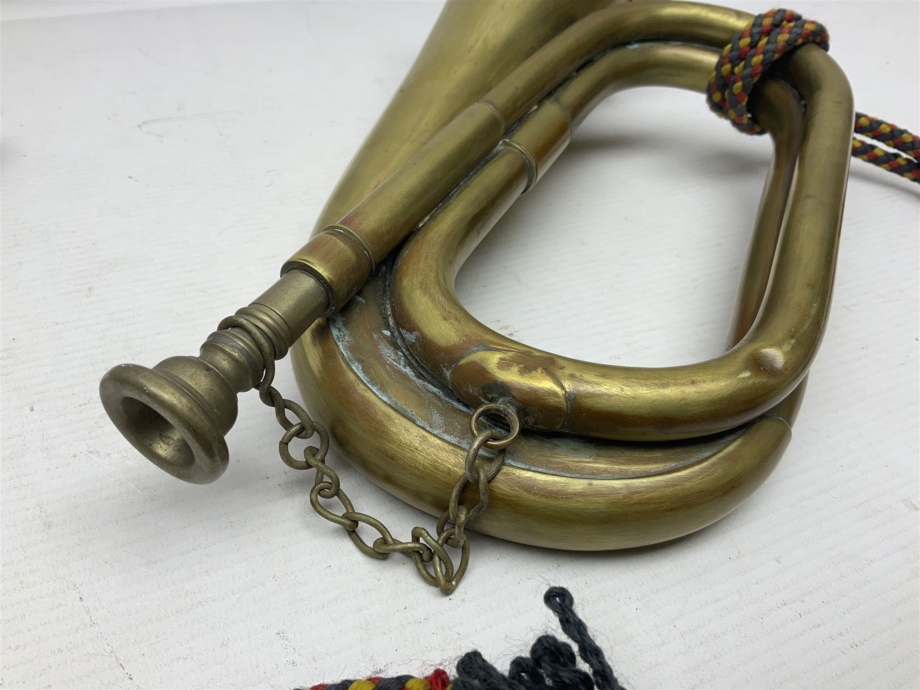 Two military brass bugles by Mayers and Harrison Ltd. Manchester each with crows foot mark and dated 1966; both with multi-coloured cord and tassels, longest 52.5cm (2)