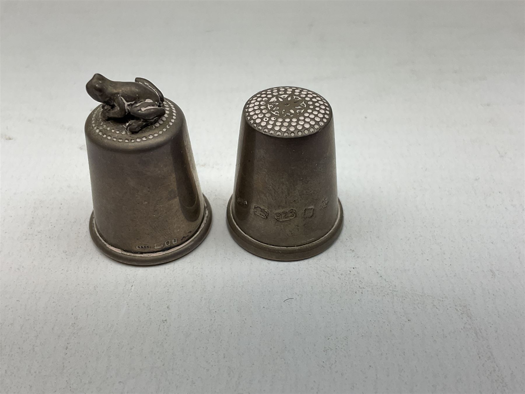 Two hallmarked silver thimbles to include late 20th century example with frog surmount stamped Clive & Clarissa Cooke, London, silver plated fork with hallmarked silver handle, together with a quantity of silver plated and other metal ware