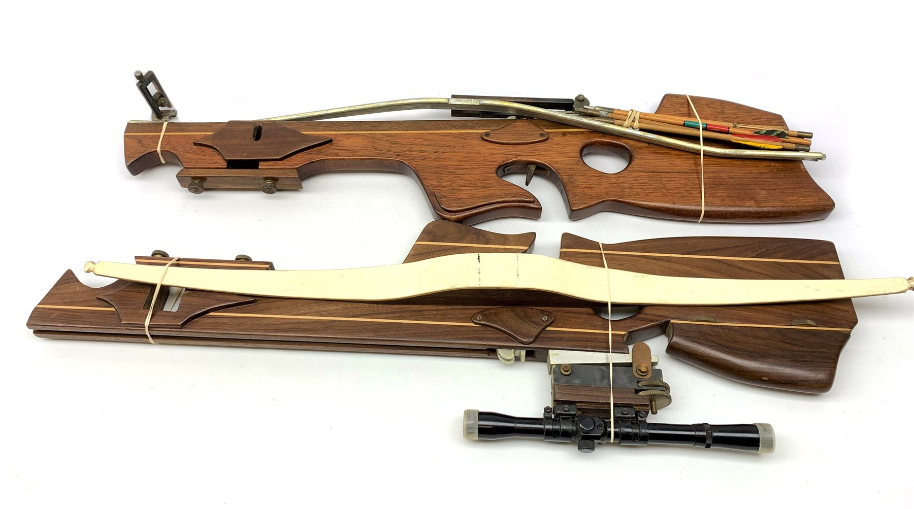 20th century crossbow with sectional mahogany shaped stock and Nikko Stirling telescopic sight L89cm; together with another similar with hinged foresight; and six arrows (8)