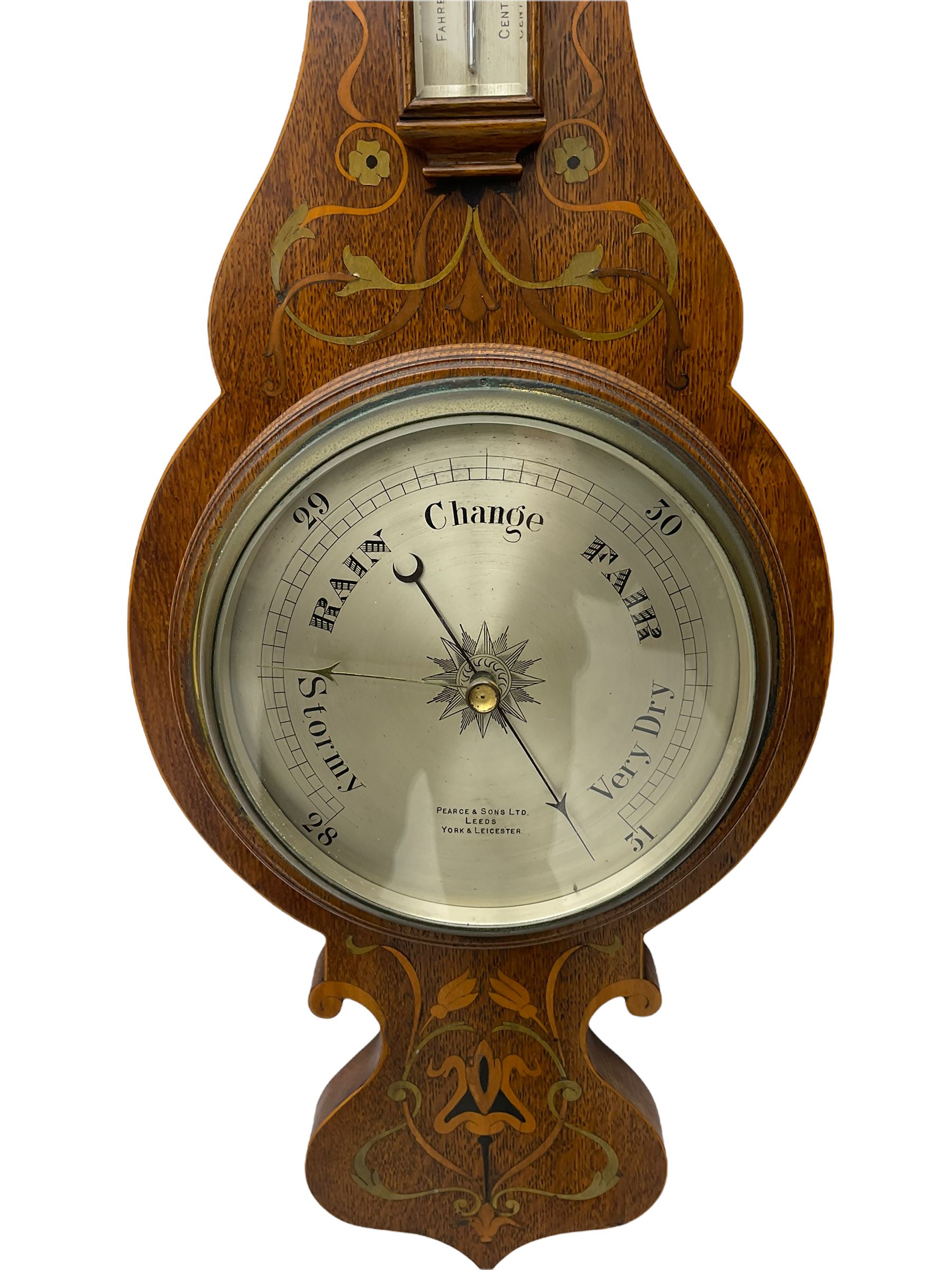 An early 20th century oak cased aneroid barometer in a decorative form