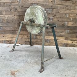 Vintage grindstone sharpening wheel mounted on metal stand, and a cast iron water pump