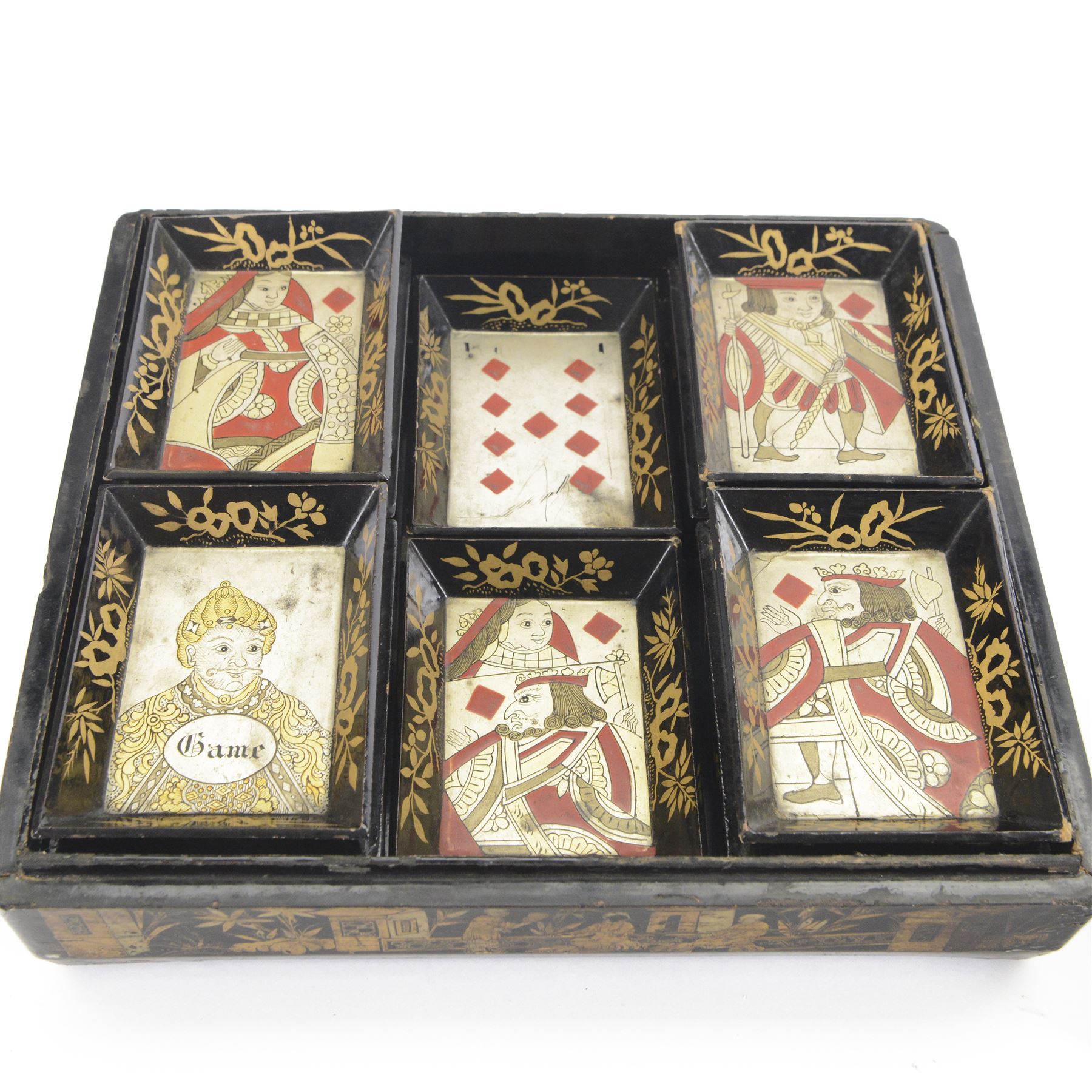 19th century Chinese export black lacquered games box, of rectangular form decorated to the exterior with figures, pagodas and bridges in a riverside landscape in red and gilt, the lift off cover opening to reveal a compartmented interior with four removable covered boxes decorated with conforming figural scenes, and eight trays decorated with stylised suits, H10cm W30cm D27cm