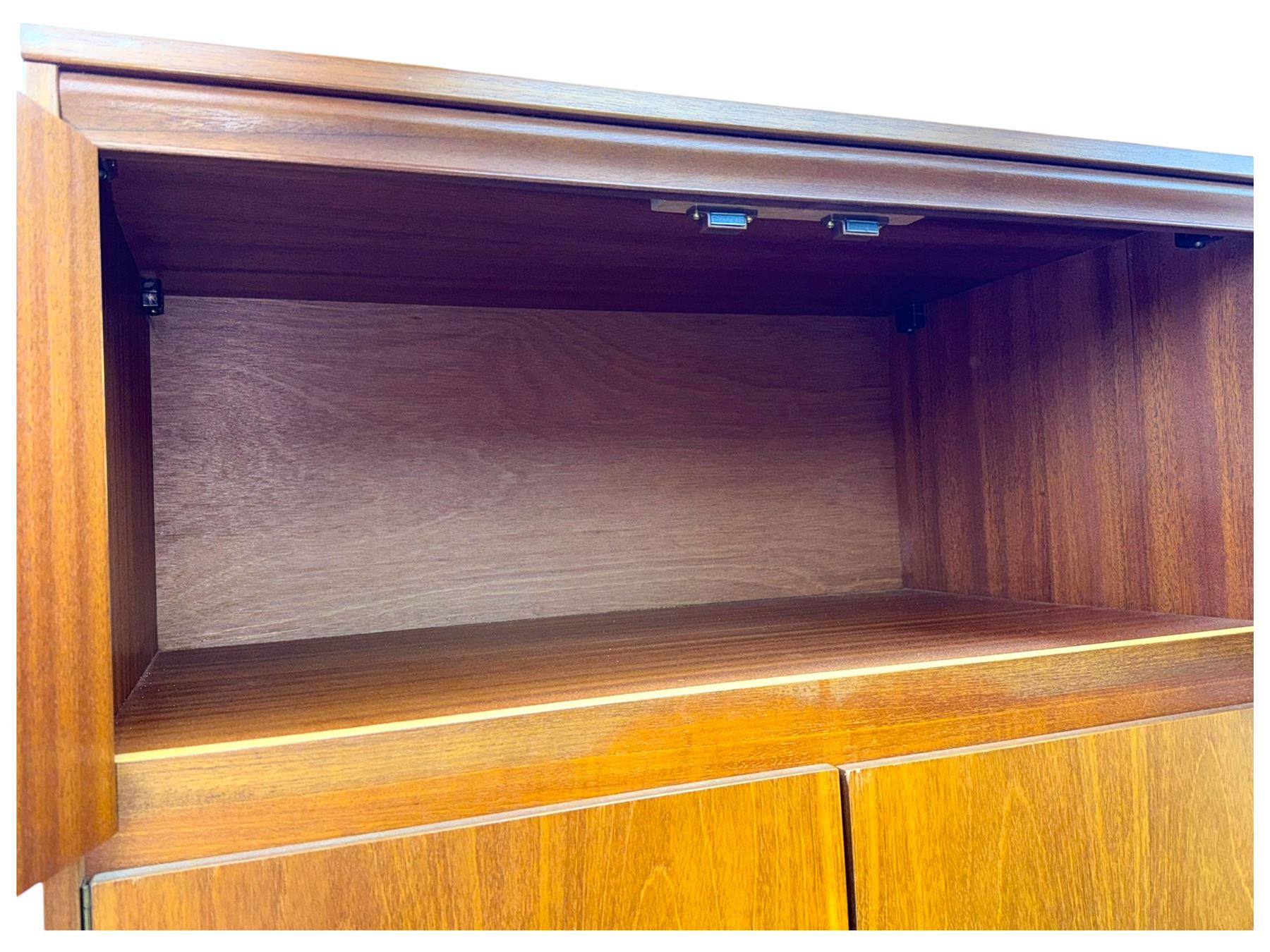 William Lawrence - mid-20th century teak double wardrobe, upper storage section over twin doors featuring recessed handles and contrasting horizontal panel, enclosing a hanging rail compartment, on plinth base with concealed castors