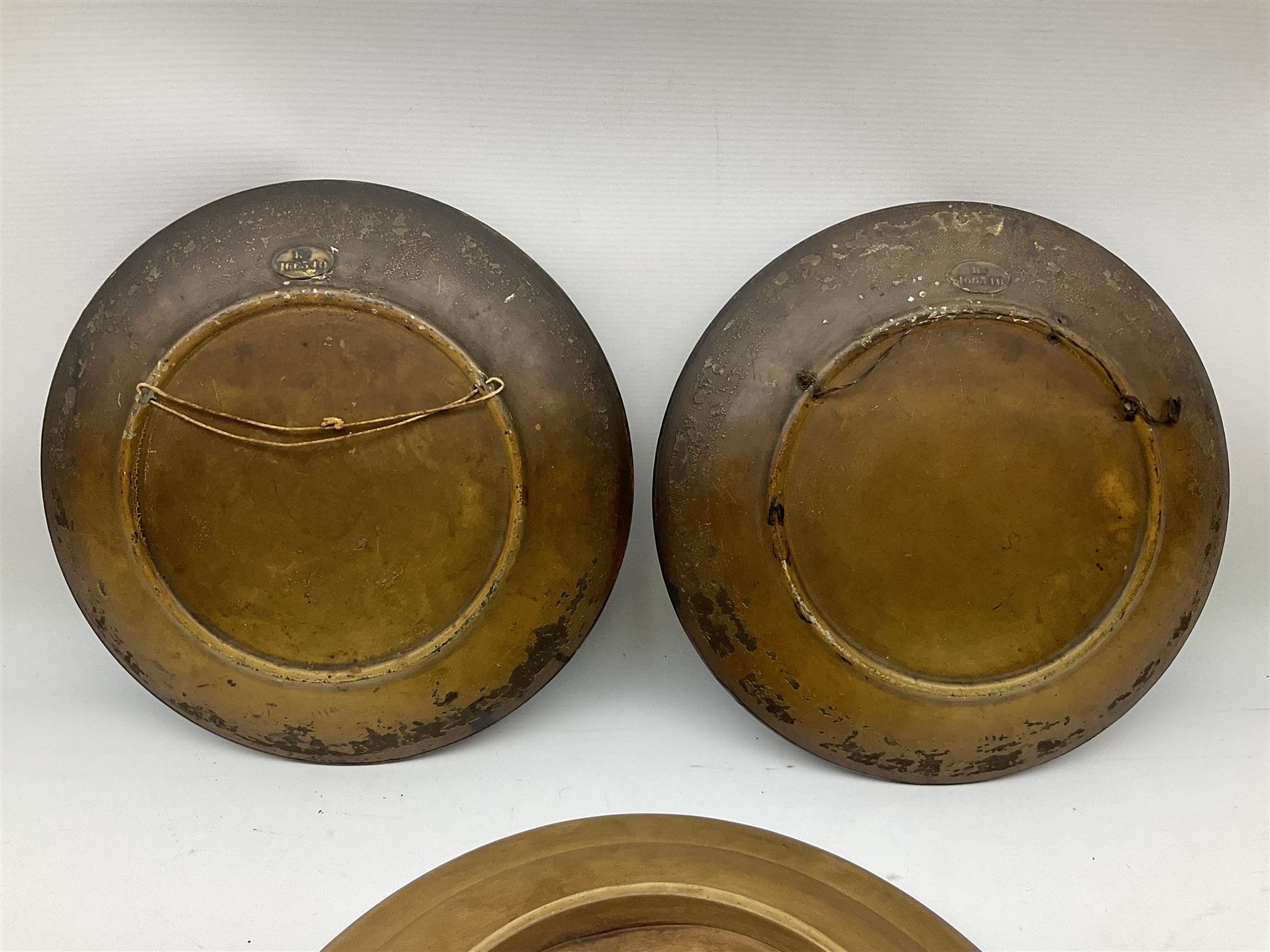 Two oil painted chargers decorated with joyful gentleman, both signed W Stanley, together with a Musterschutz charger decorated in high relief