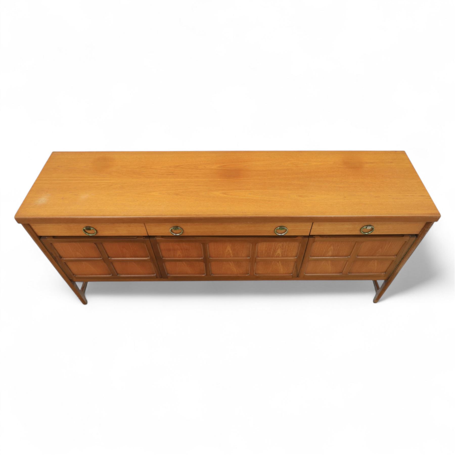 Nathan - mid 20th century teak sideboard, fitted with three drawers with brass ring handles, above a central fall front cabinet, flanked by two cupboard doors, raised on square tapering supports
