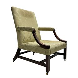 George III mahogany Gainsborough armchair, wide-seat and back upholstered in pale green damask fabric, the curved arm supports with turned roundels to terminals, raked back with out splayed supports and square front supports joined by plain stretcher rails, on brass castors