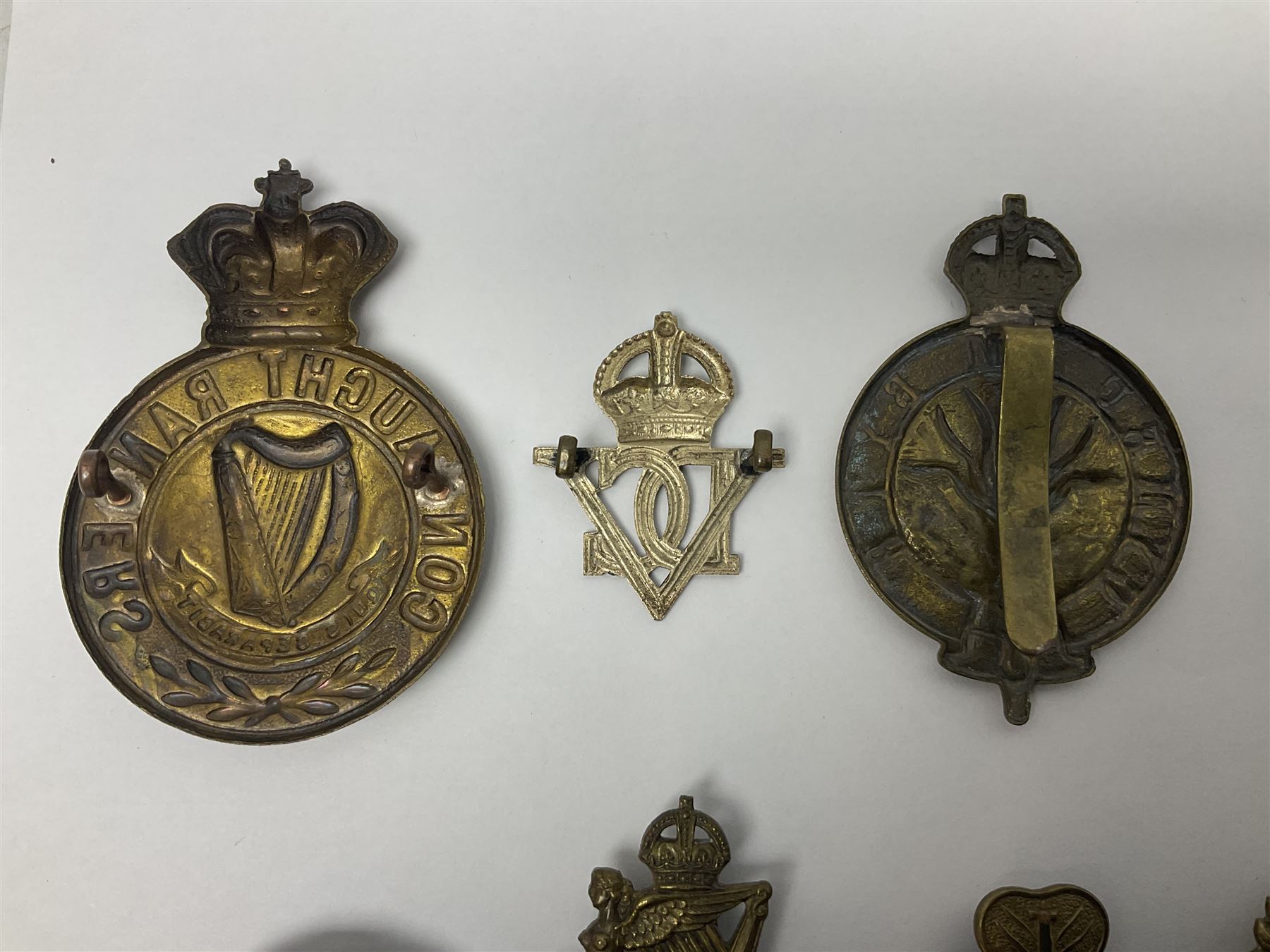 Fourteen cap badges of Irish interest including Royal Dublin Fusiliers inscribed to the slider 'From A. O'Connor 2nd Batt. Dec.2nd 1915', Connaught Rangers, South irish Horse Yeomanry, Inniskilling Fusiliers, Royal Irish Regiment etc; and seven Welsh badges including South Wales Borderers, Welsh Guards, 3rd Bn. Monmouthshire Regt. etc (21)