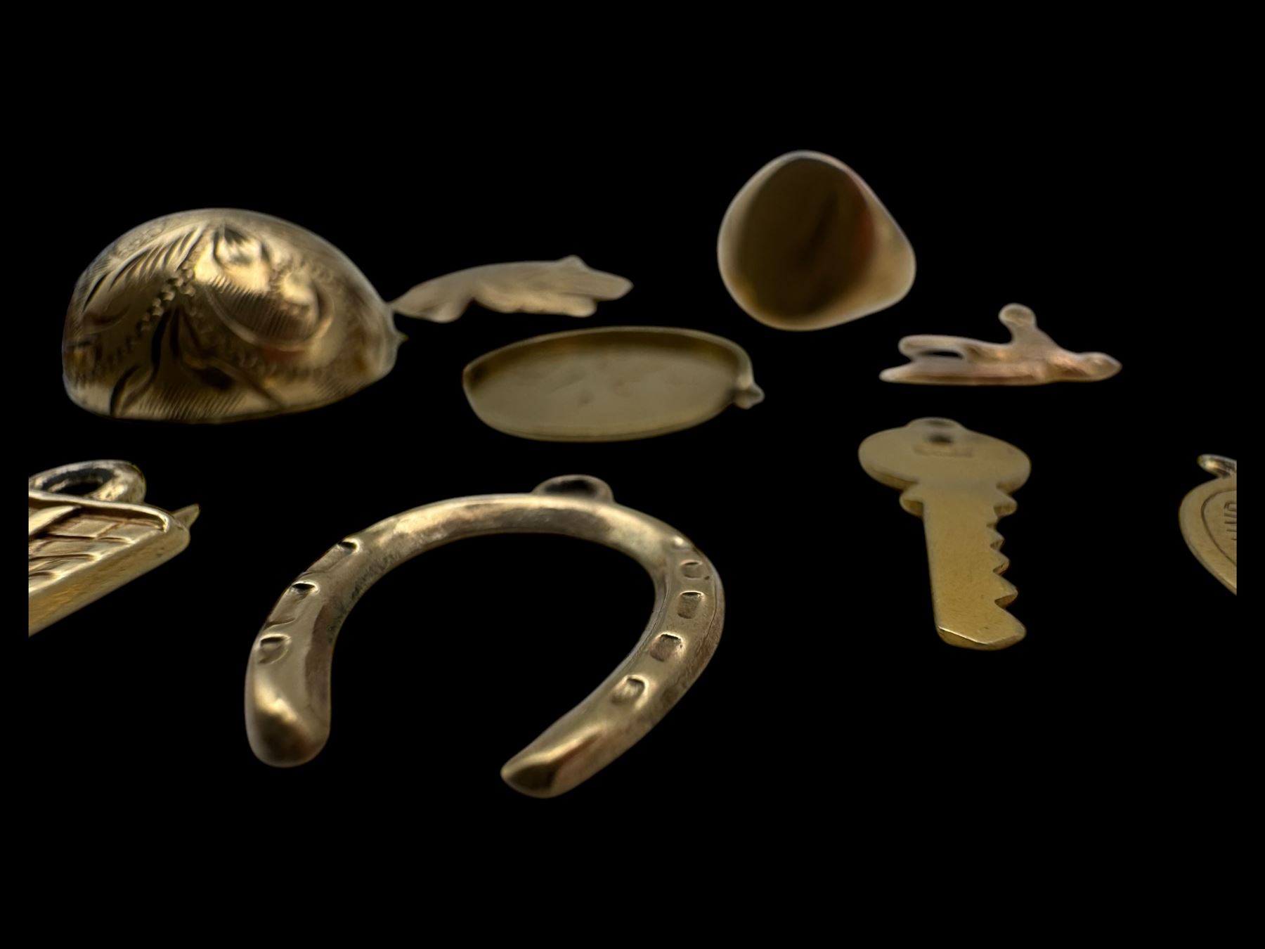 9ct gold charms, including crossed swords, signet ring, horseshoe and leaf, and a 14ct gold fireplace charm