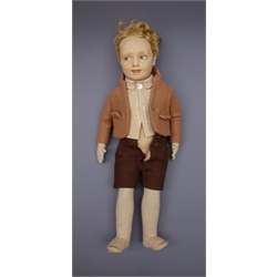  Lenci pressed felt boy doll, c1930, the swivelling head with blonde hair, painted side glancing brown eyes, smiling mouth with teeth, jointed body with stitched middle fingers, dressed in brown toned felt shirt, jacket and shorts H42cm  
