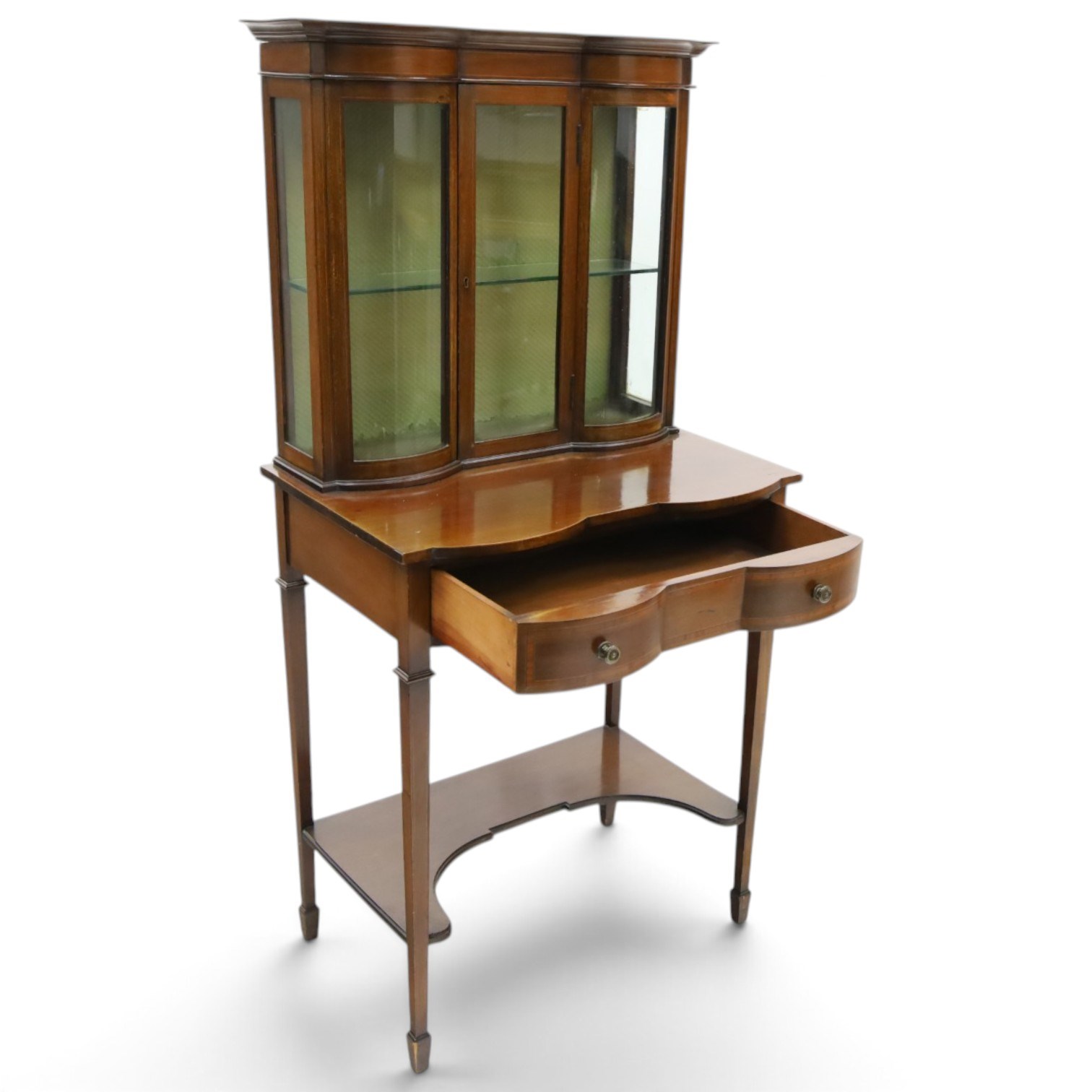 Edwardian inlaid mahogany serpentine-front side cabinet, raised back with central glazed door flanked by bow-front glass panels, the base fitted with banded and shaped frieze drawer, on square tapering supports united by concave under-tier